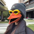 Woman wearing orange duck beak movable mask with yellow sunglasses outdoors